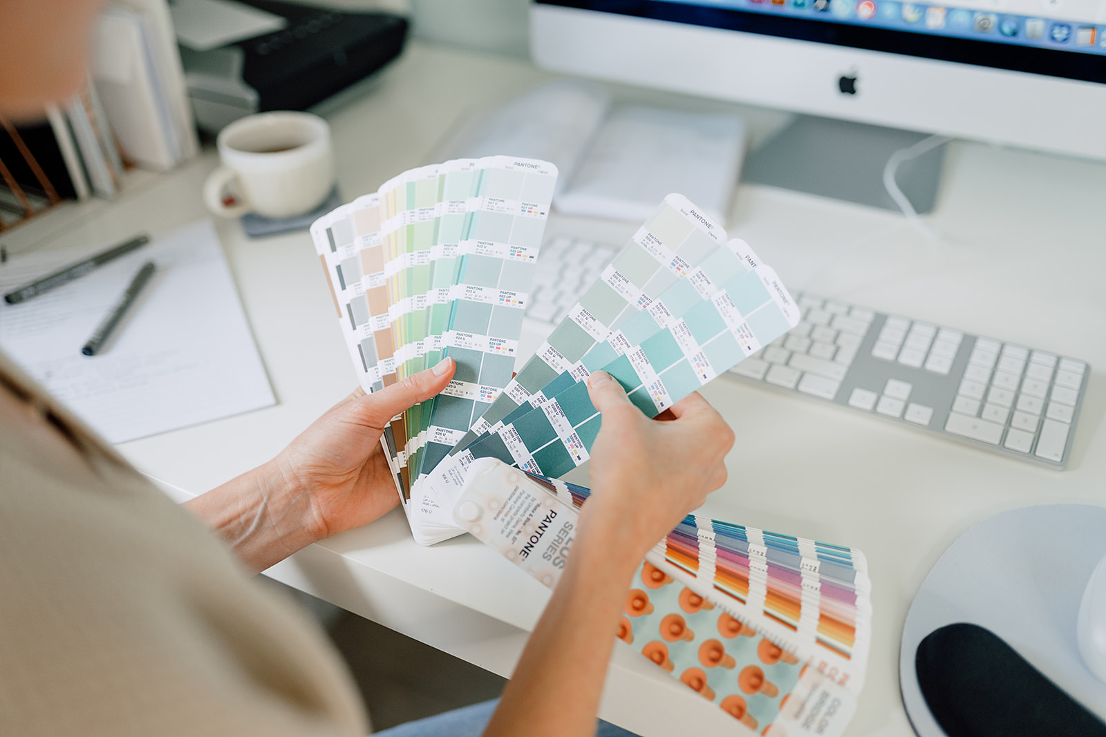 flipping through pantone book to choose brand color palette